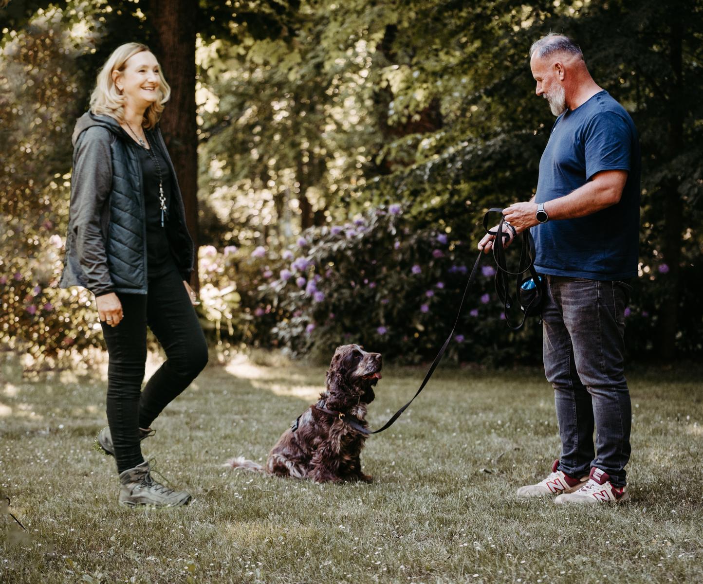 Zwei Personen mit Hund in einer Beratung